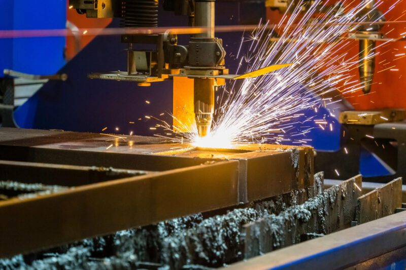 Lazerinio pjovimo mašina apdirba metalą modernioje dirbtuvėje, demonstruojant tikslumą ir pažangią technologiją.